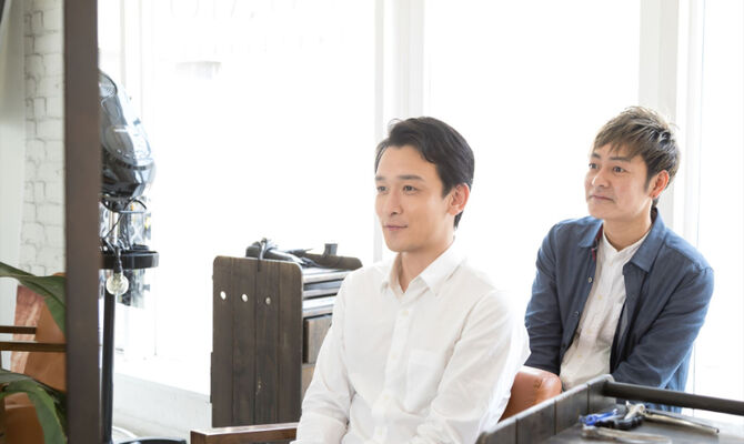 完成したヘアスタイルを確認するスタッフ